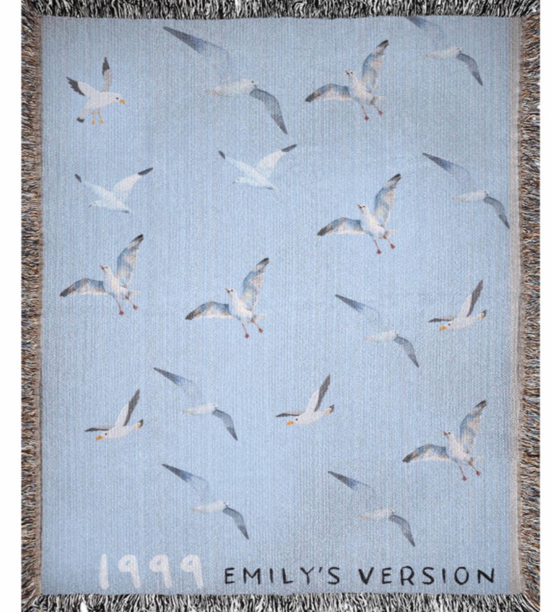May include: A blue woven tapestry with a white background featuring a repeating pattern of seagulls flying in different directions. The tapestry has a fringe border and the text "1999 Emily's Version" at the bottom.