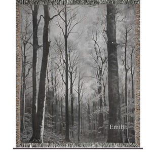 May include: Black and white woven tapestry featuring a forest scene with tall trees and a misty background. The tapestry has a fringe border and the word "Emily" is woven into the bottom right corner.