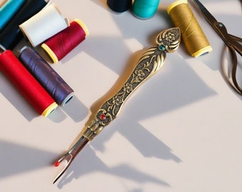 May include: A set of colorful spools of thread, a pair of scissors, and a decorative thread cutter with a jeweled handle.