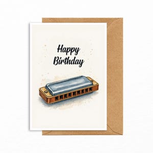 May include: A watercolor-style birthday card featuring a harmonica illustration. The card has the words "Happy Birthday" in black script. The card is on a brown envelope.