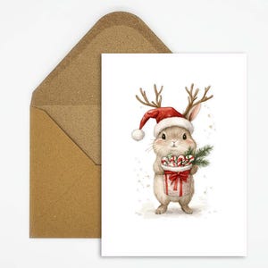 Aquarel kerstkaart, ansichtkaart konijn met gewei en cadeautjes, feestelijk en magisch voor speciale kerstgroeten voor kinderen