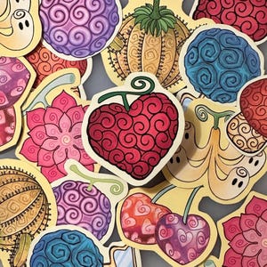 May include: A collection of colorful, stylized fruit stickers. The stickers feature various designs, including a red heart-shaped fruit, purple and blue swirling fruits, and a yellow pumpkin-like fruit. Each sticker has a yellow border.