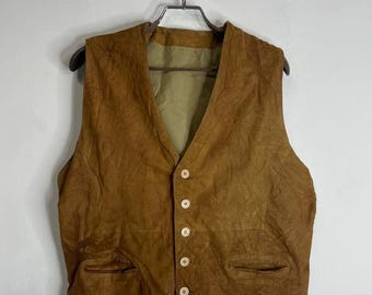 May include: A brown suede vest with a V-neck and five button closures. The vest has two pockets on the front.