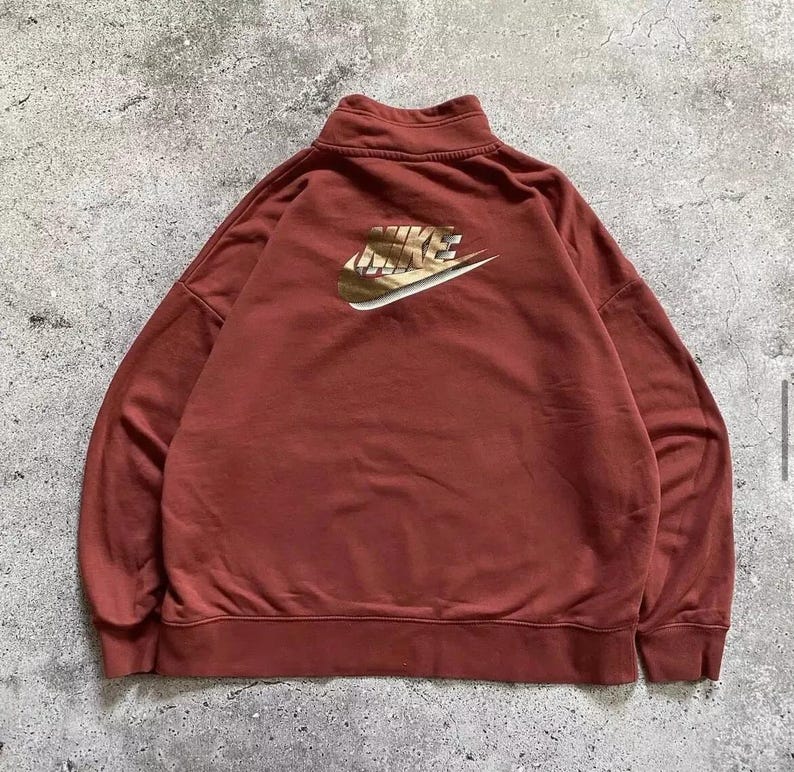 May include: A maroon sweatshirt with a gold Nike logo on the back.