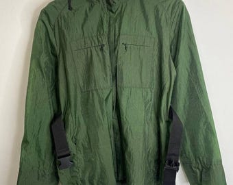May include: A green hooded jacket with black straps and buckles. The jacket has two zippered pockets on the front.