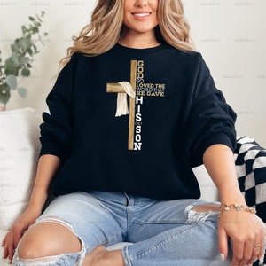 May include: Black sweatshirt with a gold cross and the text "God so loved the world that he gave his only son".