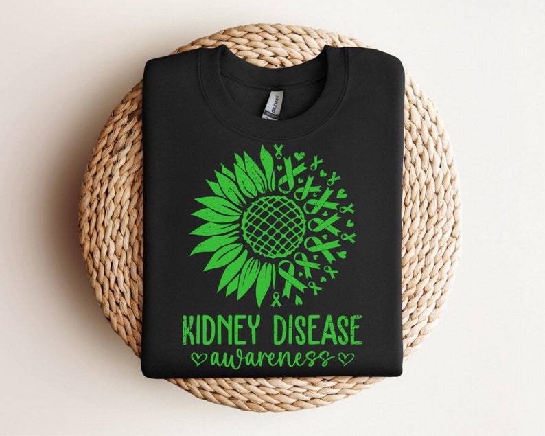 May include: Black t-shirt with a green sunflower design made of awareness ribbons. The text "Kidney Disease Awareness" is printed below the sunflower.