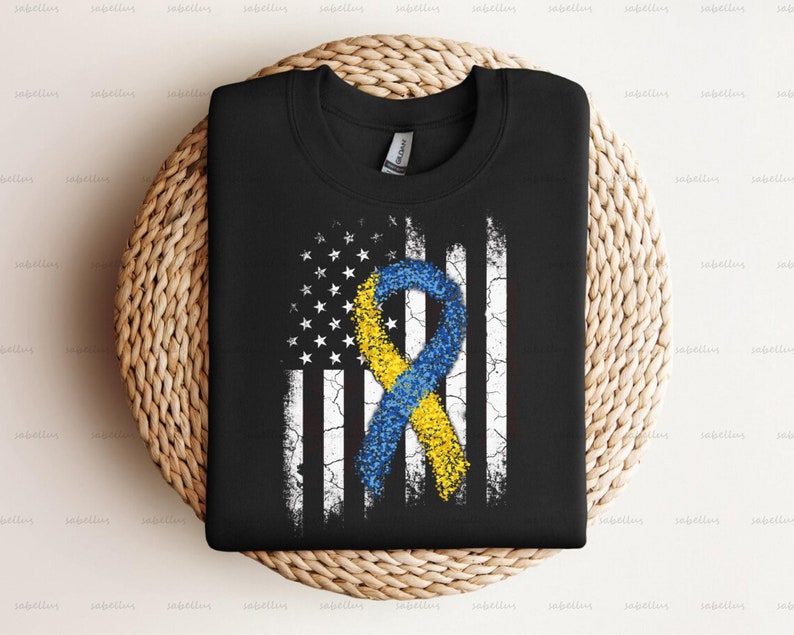 May include: Black t-shirt with a distressed American flag design featuring a yellow and blue ribbon.