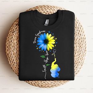 May include: Black t-shirt with a blue and yellow sunflower and an elephant with the text "Down Syndrome" and "Faith-Hope-Love" on a black background.