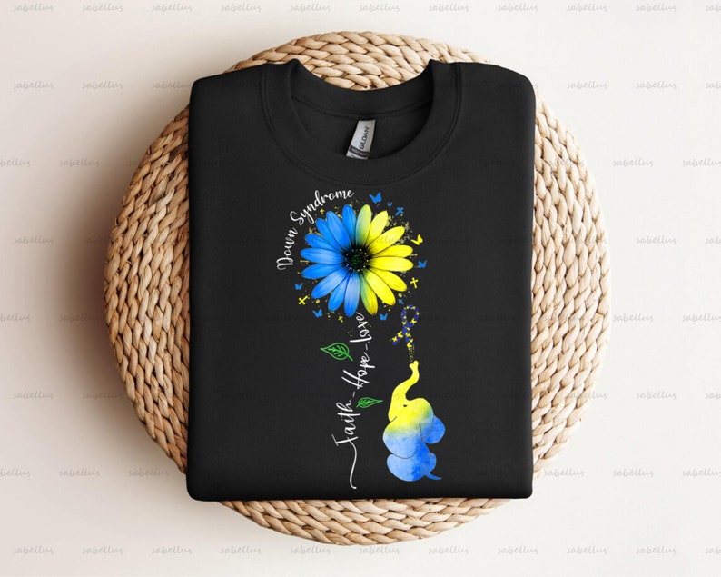 May include: Black t-shirt with a blue and yellow sunflower and an elephant with the text "Down Syndrome" and "Faith-Hope-Love" on a black background.