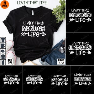 以下が含まれることがあります： 白文字で「Livin' That Monitor Life」と書かれた黒いTシャツ。左右に矢印が描かれている。Tシャツは、白いスニーカー、青いジーンズ、木製のビーズネックレスと一緒にテーブルの上に置かれている。