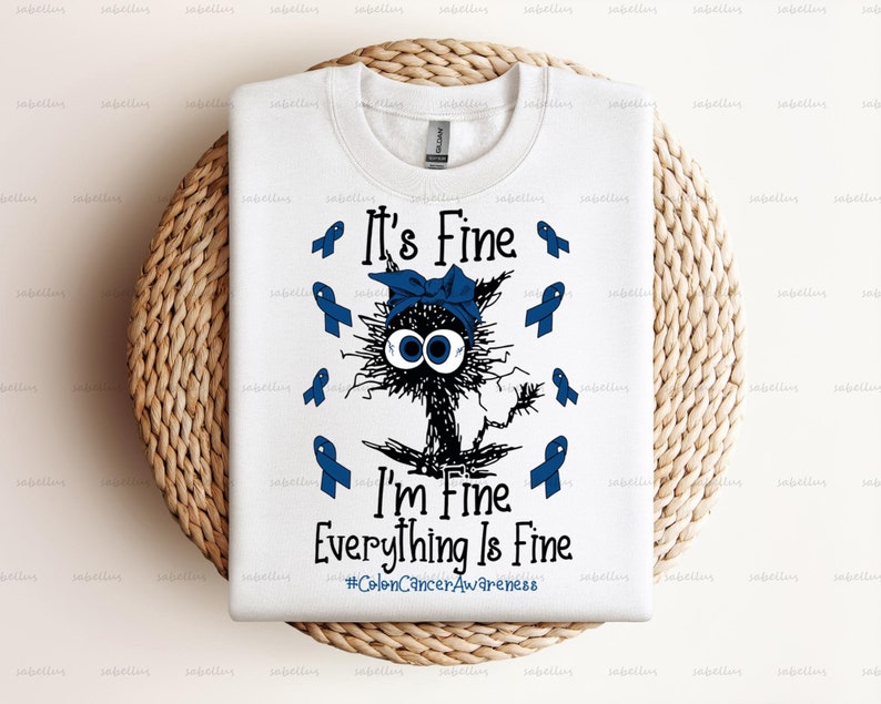 May include: White t-shirt with a blue cartoon cat wearing a blue ribbon. The text "It's Fine I'm Fine Everything Is Fine #ColonCancerAwareness" is printed on the shirt.