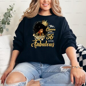 May include: Black sweatshirt with a gold glitter design featuring a black woman with a crown and the text "This Queen Makes 56 Look Fabulous".