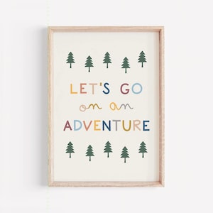 May include: A framed print with the words "LET'S GO on an ADVENTURE" in colorful letters. The print features rows of green tree illustrations above and below the text, set against a cream background.