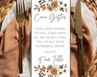 Puede incluir: Una tarjeta rectangular para la mesa con las palabras "Come Gather" y "at our Table". La tarjeta presenta detalles florales en blanco, marrón y naranja. El texto incluye un versículo bíblico del Salmo 1:9.