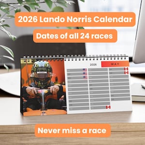 May include: A spiral-bound 2026 Lando Norris calendar. The calendar features a photo of a race car driver and the text "2026 Lando Norris Calendar" and "Dates of all 24 races". The calendar is open to the month of May.