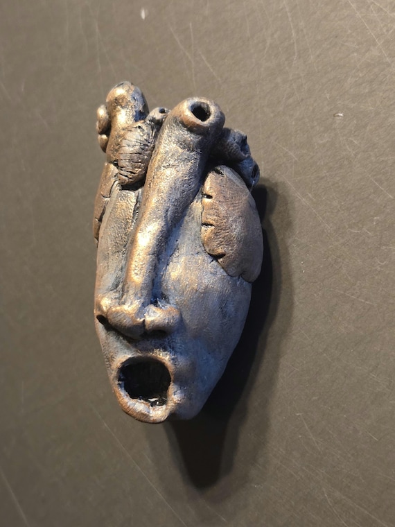 A handmade sculptural gasping heart you hang on your wall — equal parts anatomical curiosity and gothic art piece that will absolutely make guests stop and stare.