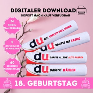 Könnte beinhalten: Drei weiße Röhren mit roter und schwarzer Schrift, die "du" und "18. Geburtstag" lautet. Der Text auf den Röhren lautet "Bist endlich volljährig, Darfst ins Casino, Darfst alleine Auto fahren, Darfst wählen".