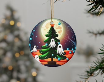 Puede incluir: Adorno navideño redondo con un árbol de Navidad verde, figuras de fantasmas blancos, una luna llena y un cielo estrellado. El adorno cuelga de una cuerda dorada. El diseño tiene un tema caprichoso y espeluznante.