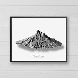Può includere: Una stampa incorniciata che mostra una mappa topografica in rilievo tridimensionale in scala di grigi del Monte Shasta. Il testo sotto la montagna recita Mount Shasta ed Elevation - 14.179 ft. L'opera è inserita in una cornice nera.