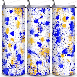 May include: A white tumbler with a blue and gold splatter paint design. The design is abstract and random, with blue and gold paint splatters of various sizes.