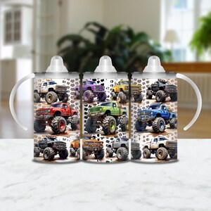 May include: Three white insulated cups with handles and lids. Each cup features a different color monster truck design with a white background and black tire tracks. The trucks are red, green, and blue.