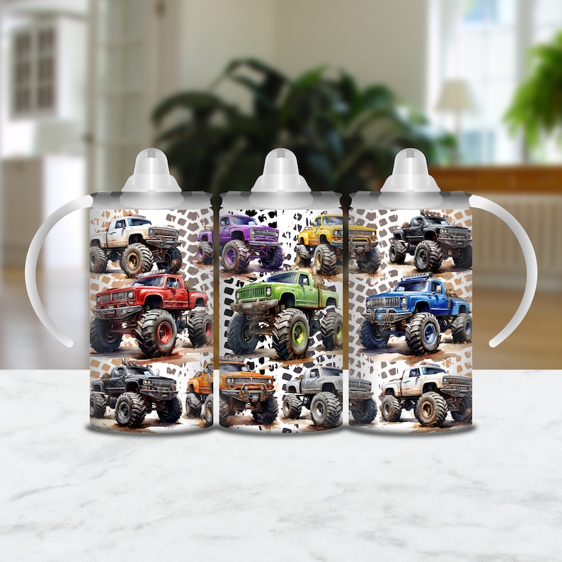 May include: Three white insulated cups with handles and lids. Each cup features a different color monster truck design with a white background and black tire tracks. The trucks are red, green, and blue.