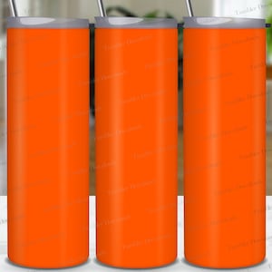 Puede incluir: Tres vasos de acero inoxidable de color naranja con tapa plateada. Los vasos están sobre una superficie blanca.