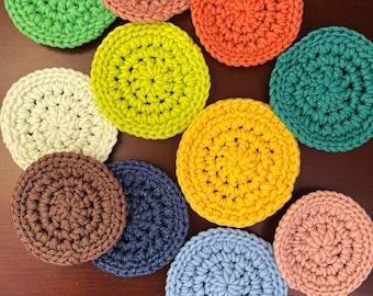 Peut inclure: Dix sous-verres en crochet de différentes couleurs, notamment vert, jaune, orange, marron, bleu et rose. Les sous-verres sont circulaires et présentent un motif texturé.