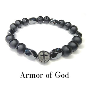 May include: Black beaded bracelet with a silver cross charm. The bracelet is labeled "Armor of God".
