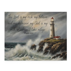 Op de afbeelding: Een legpuzzel met een vuurtoren op een rotsachtige klif, met golven die eronder breken. De lucht is bewolkt. De tekst luidt: "De Heer is mijn rots, mijn vesting...Psalm 18:2."