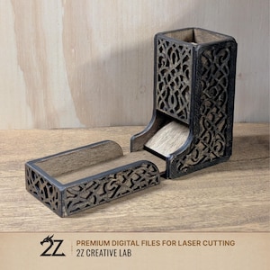 Peut inclure: Un ensemble de tour et de plateau à dés en bois. La tour est rectangulaire avec des motifs découpés complexes et une finition sombre. Le plateau est séparé et correspond à la conception de la tour. L'ensemble est sur une surface en bois. Le texte "2Z CREATIVE LAB" est visible.