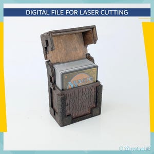 May include: A wooden card holder with a hinged lid, filled with playing cards. The box is brown with carved details and a textured appearance. The text "DIGITAL FILE FOR LASER CUTTING" is at the top.