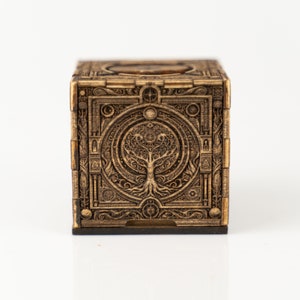 Puede incluir: Una caja de madera con un diseño tallado de un árbol de la vida. La caja es marrón y tiene un acabado de madera oscura.