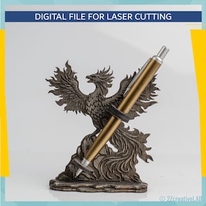 Könnte beinhalten: Ein Holz-Stifthalter mit einem lasergeschnittenen Phönix-Design, der einen goldenen Stift hält. Der Stifthalter ist dunkelbraun und weist aufwendige Details auf. Der Text "DIGITAL FILE FOR LASER CUTTING" befindet sich oben.