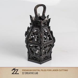 May include: A dark brown, laser-cut wooden lantern featuring intricate filigree patterns and skull motifs on each side. The lantern has a hexagonal base, a top handle, and flame-like decorative edges. Text at the bottom reads 2Z CREATIVE LAB.