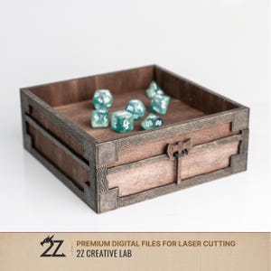 May include: A wooden dice box with a decorative design and a latch closure. The box contains several translucent teal dice with white numbering. The box is made of dark brown wood with lighter brown accents.