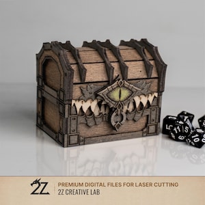 May include: A brown wooden chest with a laser-cut design featuring a central eye motif and sharp teeth along the lid. The box has dark structural ribs and is accompanied by several black polyhedral dice. Text reads: 2Z PREMIUM DIGITAL FILES FOR LASER CUTTING 2Z CREATIVE LAB.