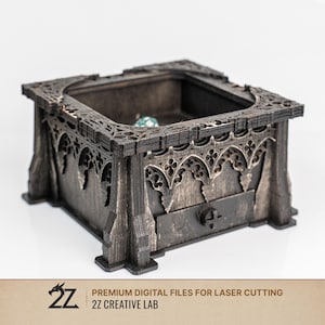 Può includere: Una scatola di legno scuro con intricate incisioni in stile gotico e un piccolo cassetto. La scatola ha una forma quadrata con una parte superiore incassata e bordi decorativi. Il testo "PREMIUM DIGITAL FILES FOR LASER CUTTING" e "2Z CREATIVE LAB" sono visibili.