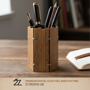 May include: A wooden pen holder with a textured, rustic design, holding several pens and pencils. The holder is brown with silver accents and sits on a wooden surface. The image also includes a notebook and the text "PREMIUM DIGITAL FILES FOR LASER CUTTING 2Z CREATIVE LAB."