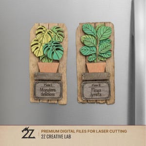 May include: Two wooden plant magnets. One features a Monstera deliciosa plant, the other a Ficus lyrata. Each plant is in a wooden pot on a wooden plank. The magnets have labels with the plant names. The bottom of the image has the text "PREMIUM DIGITAL FILES FOR LASER CUTTING".