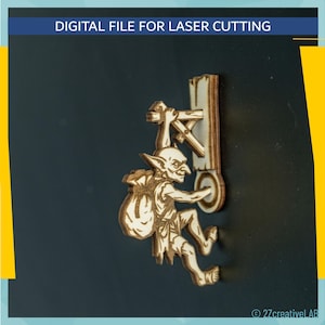 Può includere: Un design in legno tagliato al laser raffigurante un goblin che si arrampica su una struttura in legno. Il goblin porta un sacco e ha un'espressione maliziosa. Il testo "DIGITAL FILE FOR LASER CUTTING" è in alto.