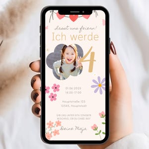 Op de afbeelding: Een smartphone toont een verjaardagsuitnodiging met de tekst "Lasst uns feiern! Ich werde 4". De uitnodiging bevat een foto van een lachend kind, bloemmotieven en evenementdetails. De telefoon wordt in een hand gehouden.