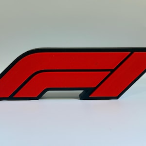 May include: A red and black Formula 1 logo. The logo features a stylized 'F' and '1' design, with a red shape outlined in black. The design is a recognizable symbol of Formula 1 racing.