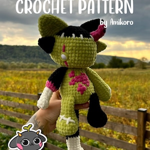 Może przedstawiać: Ręcznie robiona szydełkowa lalka w stylu Frankensteina. Lalka ma zielone ciało, czarne akcenty i różowe detale. Tekst "CROCHET PATTERN" jest wyświetlany u góry, a pod nim "by Amikoro".