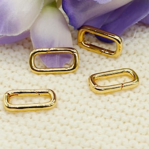 May include: Four gold-toned metal rectangle-shaped clasps with a spring-loaded closure.