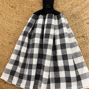 May include: Black and white checked kitchen towel with a black crocheted loop and button.