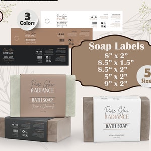 May include: Five different sizes of soap labels with the text "Pure Glow Radiance Bath Soap" in a brown, black, and white color scheme. The labels are shown on top of bars of soap.
