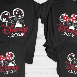 May include: Black t-shirts featuring a Disney design. The design includes Mickey Mouse ears, a castle, fireworks, and the text "Disney 2020" in red. Some shirts feature a red and white polka dot bow.