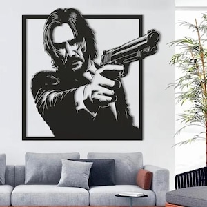 May include: Black and white silhouette of a person holding a gun, framed in a black frame. The image is mounted on a white wall.